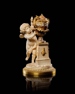 statue de Cupidon tenant une horloge, posée sur un socle, sur fond noir