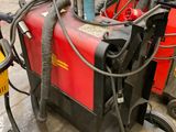 une soudeuse rouge et noire posée par terre