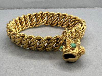 bracelet en or orné d'une pierre verte au centre