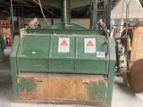 a green machine that is sitting in a warehouse