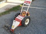 a small lawn mower that is sitting on the side of the road