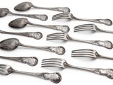 a lot of forks and spoons on a white surface