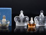 three bottles of perfume sitting on top of a table next to a box