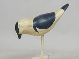 un oiseau en bois posé sur un socle en bois