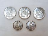 four different types of silver coins are shown on a white surface