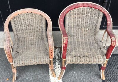 two wicker chairs sitting next to each other on the sidewalk