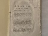 un livre ouvert sur lequel se trouve une feuille de papier