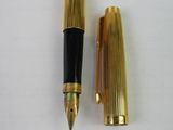 a gold pen and a black pen sitting next to each other