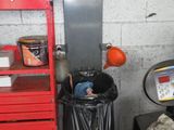 une photo d'un garage avec un établi rouge et une poubelle