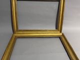 un cadre doré vide contenant un miroir, sur fond blanc