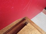 a picture of a corner of a room with a red wall and white carpet