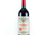 une bouteille de vin rouge posée sur une table blanche