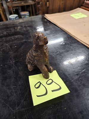 a small dog figurine sitting on a table next to a piece of paper
