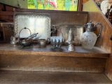 de nombreux objets en argent posés sur une étagère en bois