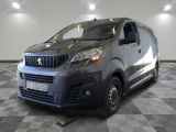 La petite camionnette est garée dans une grande pièce au sol carrelé en damier.