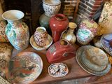 many vases and plates on a table with a fire place in the background