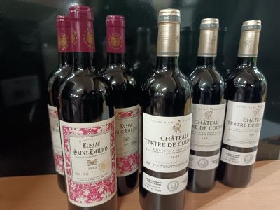 six bouteilles de vin rouge sont alignées sur une table