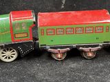 a green and red toy train on a black surface