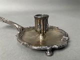 a silver plate with a silver candle holder on it