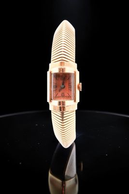 an image of a watch on a table with a black background