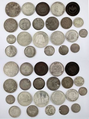 an assortment of silver and bronze coins on a white surface