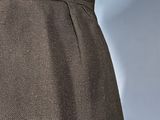 a close up of a woman ' s torso wearing a black skirt