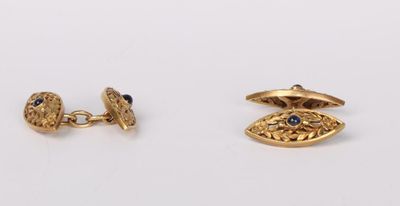 a pair of gold cufflinks with sapphire eyes