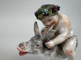 a figurine of a boy riding a donkey