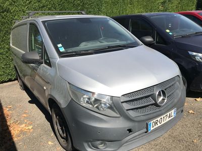 une camionnette argentée garée sur un parking à côté d'autres voitures