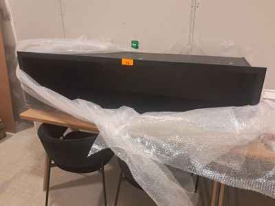 a black box sitting on top of a table covered in plastic