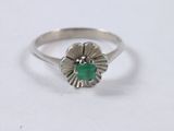 a close up of a silver ring with a green stone