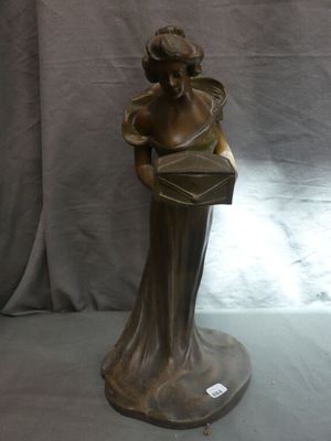 bronze statue of a woman holding a purse on a pedestal