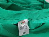 a close up of a green t - shirt with a tag on it