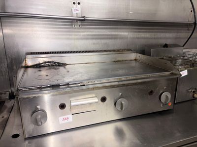 stainless steel counter top in a commercial kitchen with a fryer on it