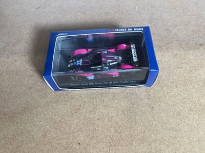 a pink toy car in a box on the floor