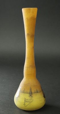 un vase jaune orné d'un motif, posé sur une table