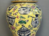 a yellow vase with blue and white designs on it
