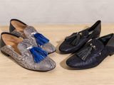 a pair of shoes with tassels on them sitting on a table