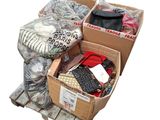 une caisse remplie de vêtements et d'autres articles posée sur une palette