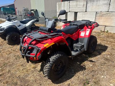 two atvs parked next to each other on the grass