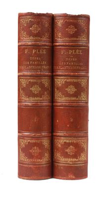 two old books sitting on top of each other on a white surface