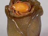 a glass vase with a green leaf on top of it