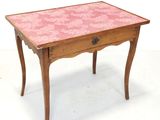 une petite table en bois recouverte d'une nappe rose