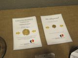 two pamphlets on a table with a gold coin on it