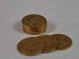 a pile of gold coins sitting on a white surface
