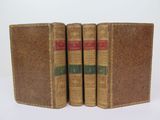 three old books sitting on top of each other on a white surface
