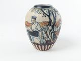 un petit vase posé sur une surface blanche