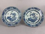 two blue and white plates with flowers and birds on them