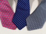 four different colored ties are arranged in a circle on a white surface