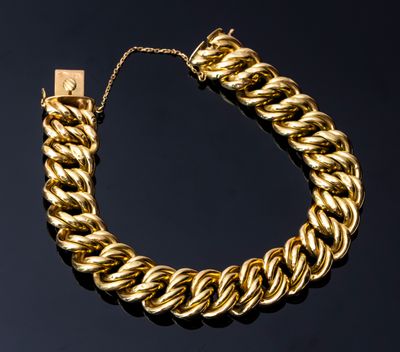 un bracelet à chaîne en or avec un fermoir sur fond noir